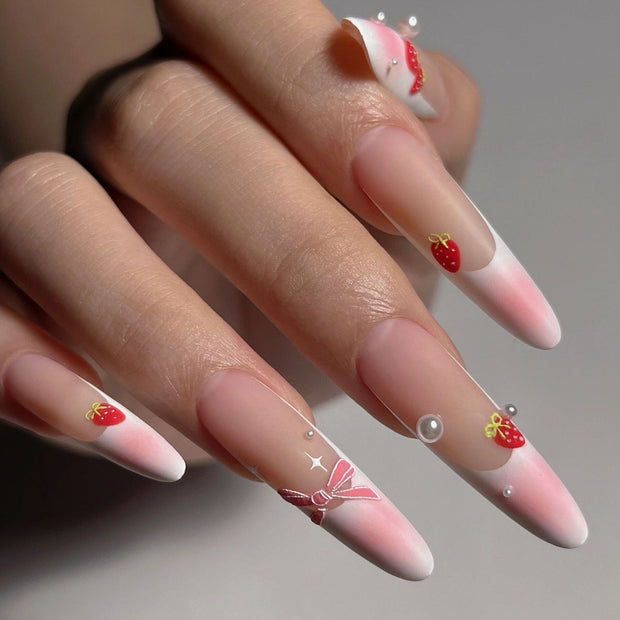 Matte extra-long stiletto nails with pink-nude gradient tips, decorated with hand-painted strawberries, bows, and pearls for a sweet, feminine vibe.
