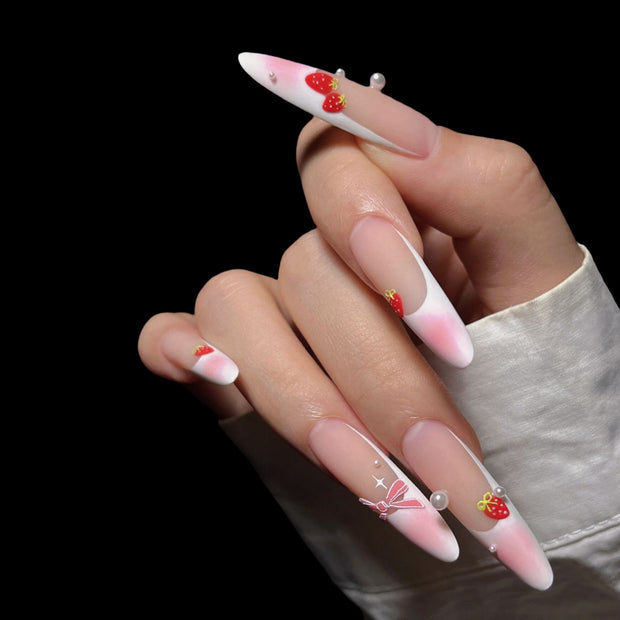 Matte extra-long stiletto nails with pink-nude gradient tips, decorated with hand-painted strawberries, bows, and pearls for a sweet, feminine vibe.
