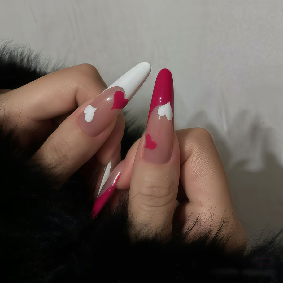 Glossy extra-long stiletto nails with nude gradient base, white French tips, and dual-tone hearts for a sweet, romantic vibe.