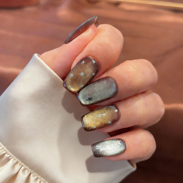 Bronze Lumina cat eye press-on nails with holographic glitter and starburst details