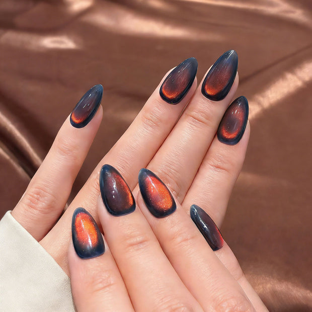 Deep blue press-on nails with a vivid red magnetic cat eye shimmer