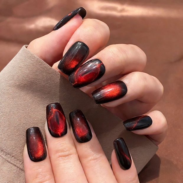 Black to red ombre press-on nails with bold red spiderweb designs