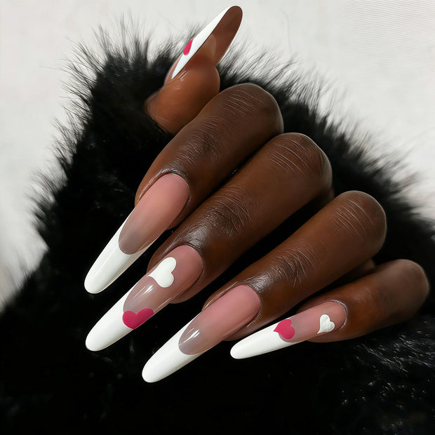 Glossy extra-long stiletto nails with nude gradient base, white French tips, and dual-tone hearts for a sweet, romantic vibe.